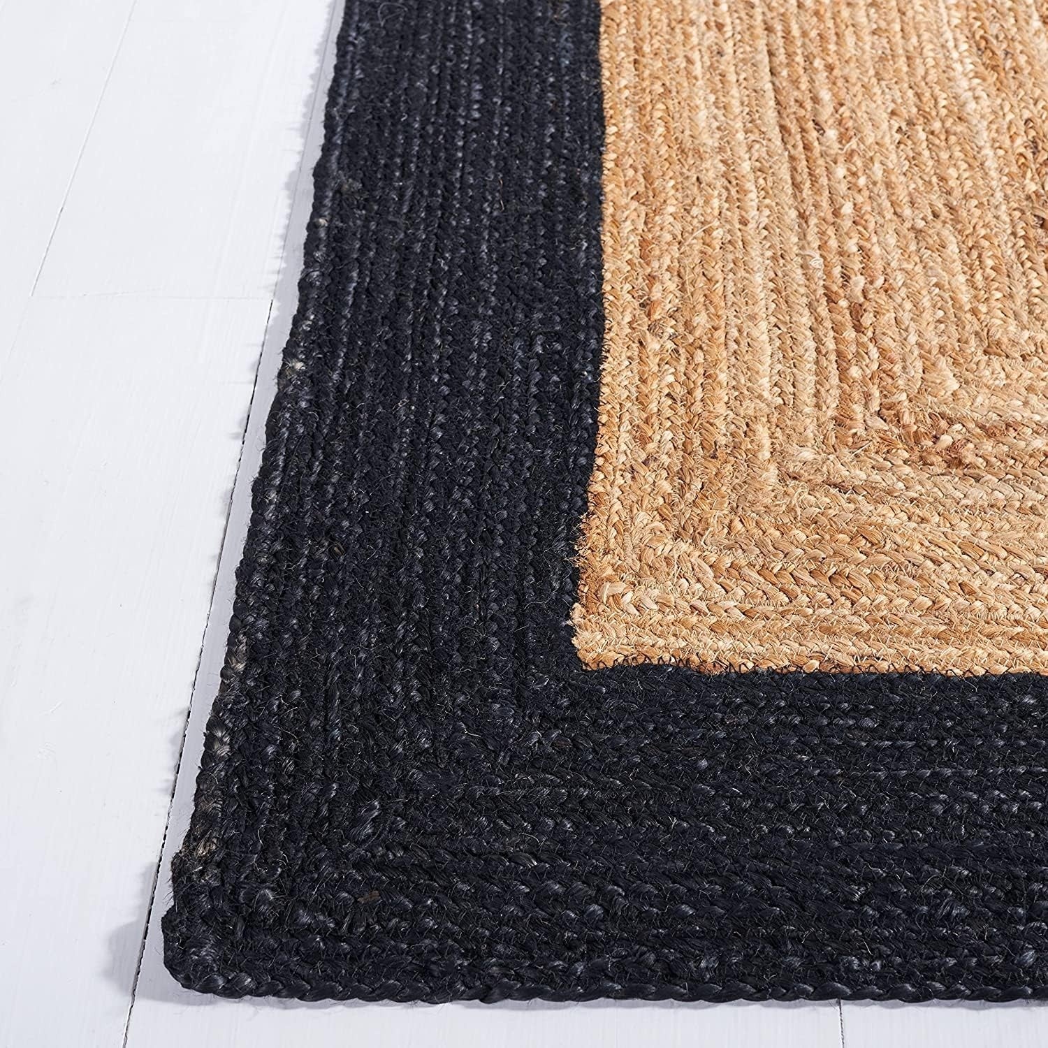 Black and beige textured rug corner on a white floor