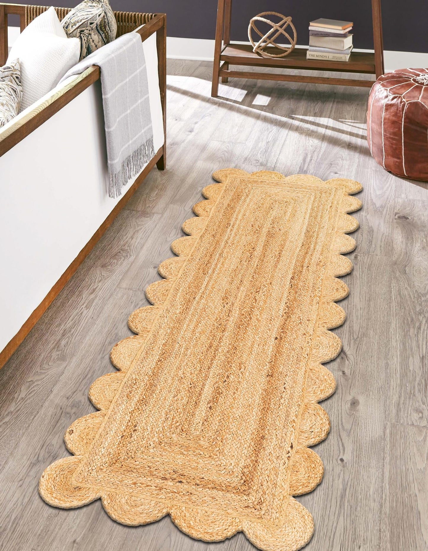 Scalloped-edge jute rug on a wooden floor in a room with furniture.