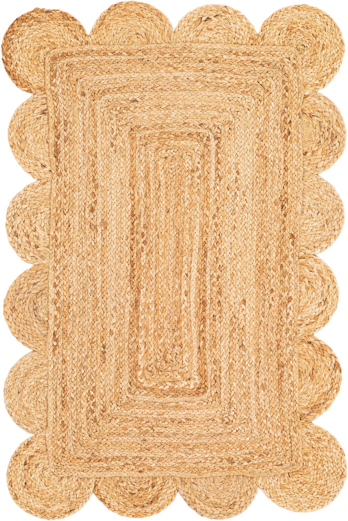 Beige braided rug with scalloped edge on a white background