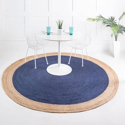 Round blue and beige rug in front of a white dining table with chairs.
