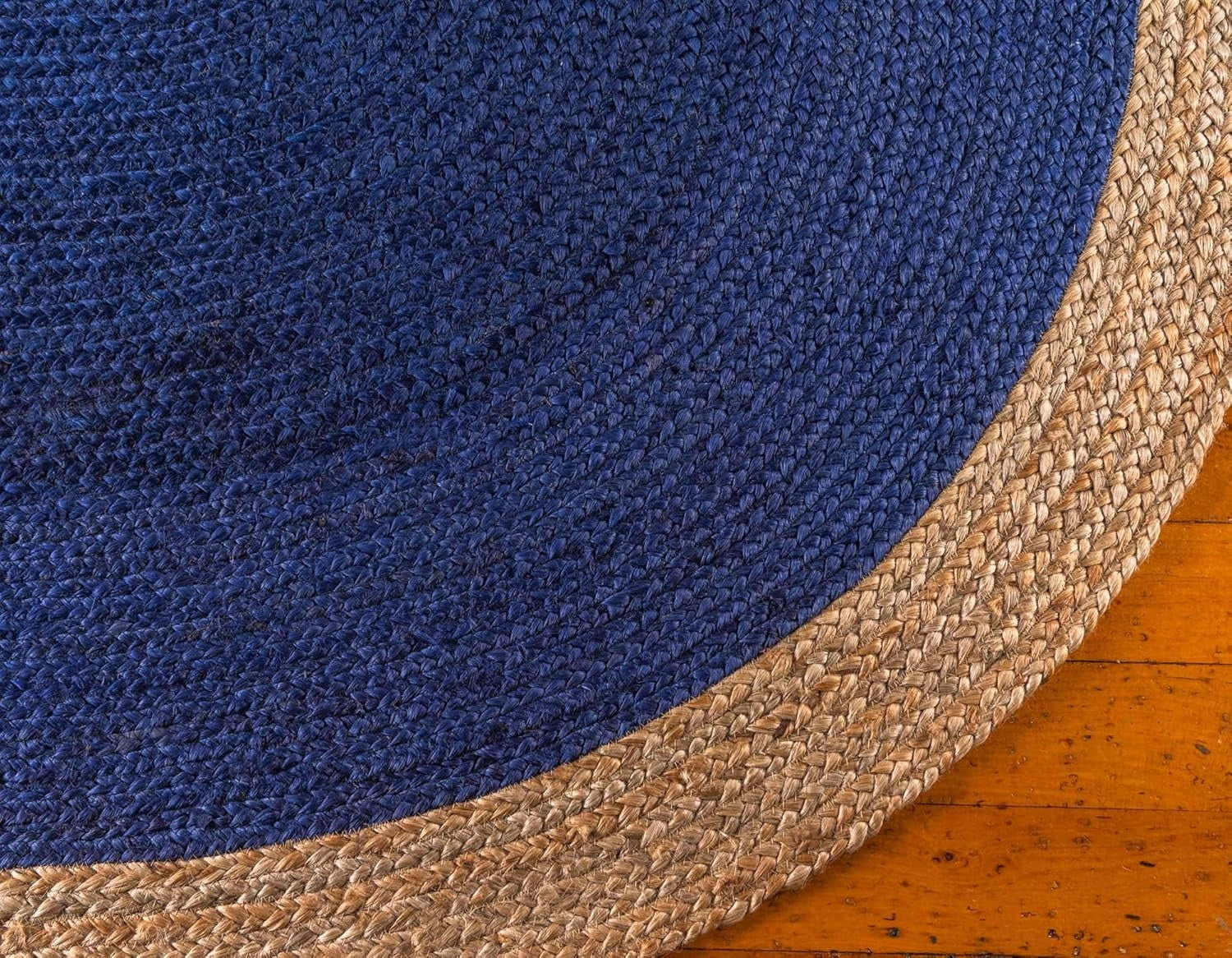 Close-up of a blue and beige woven rug on a wooden floor.