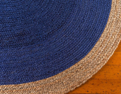 Close-up of a blue and beige woven rug on a wooden floor.
