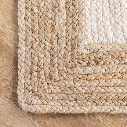 Close-up of a braided natural fiber rug on a wooden floor.