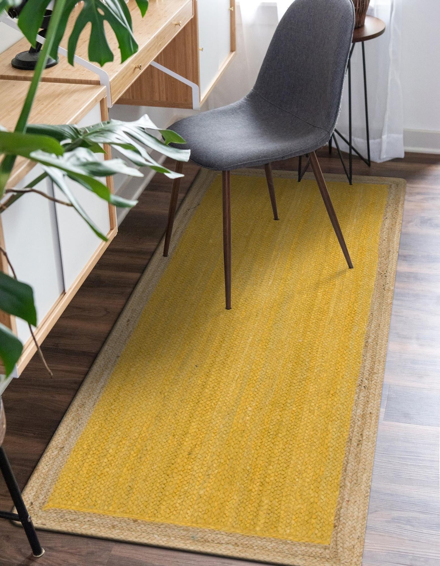 Yellow rug with a gray chair on a wooden floor