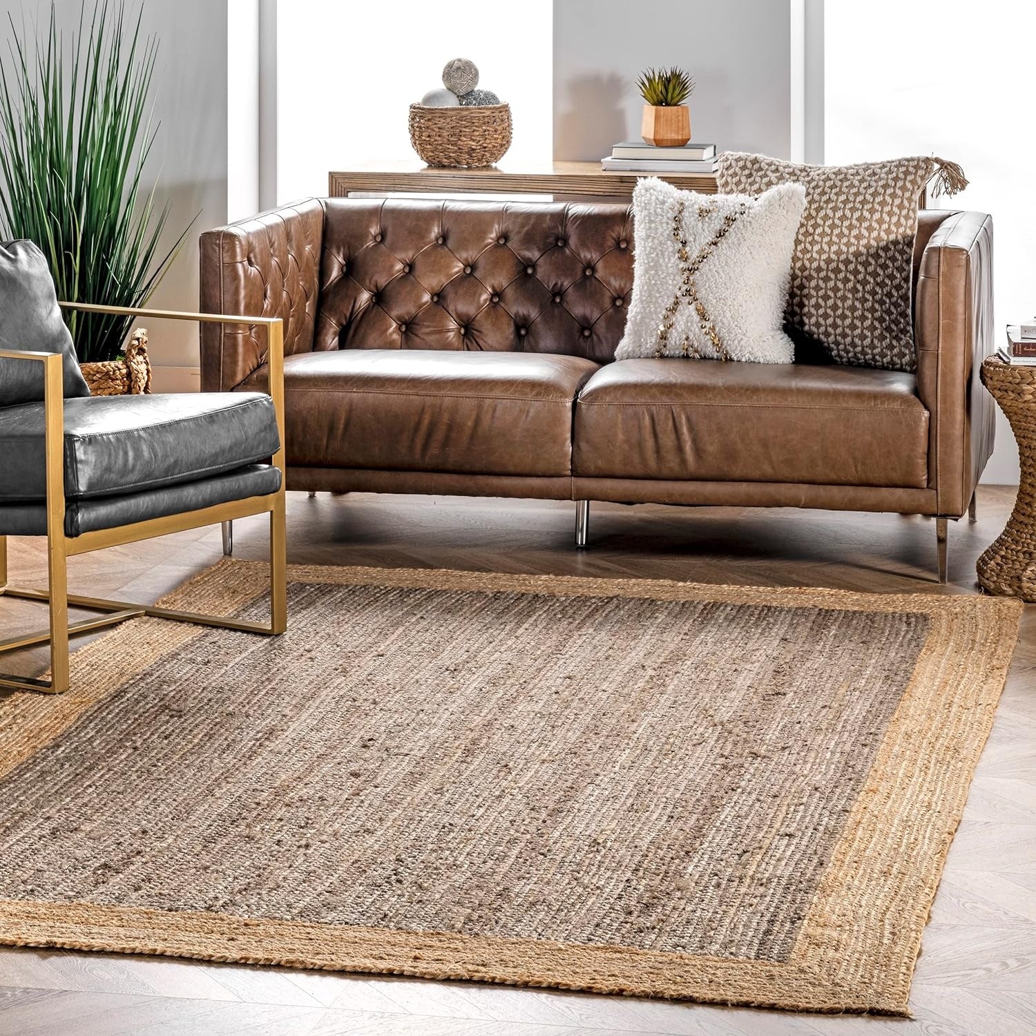 Brown leather sofa with decorative pillows in a living room setting.