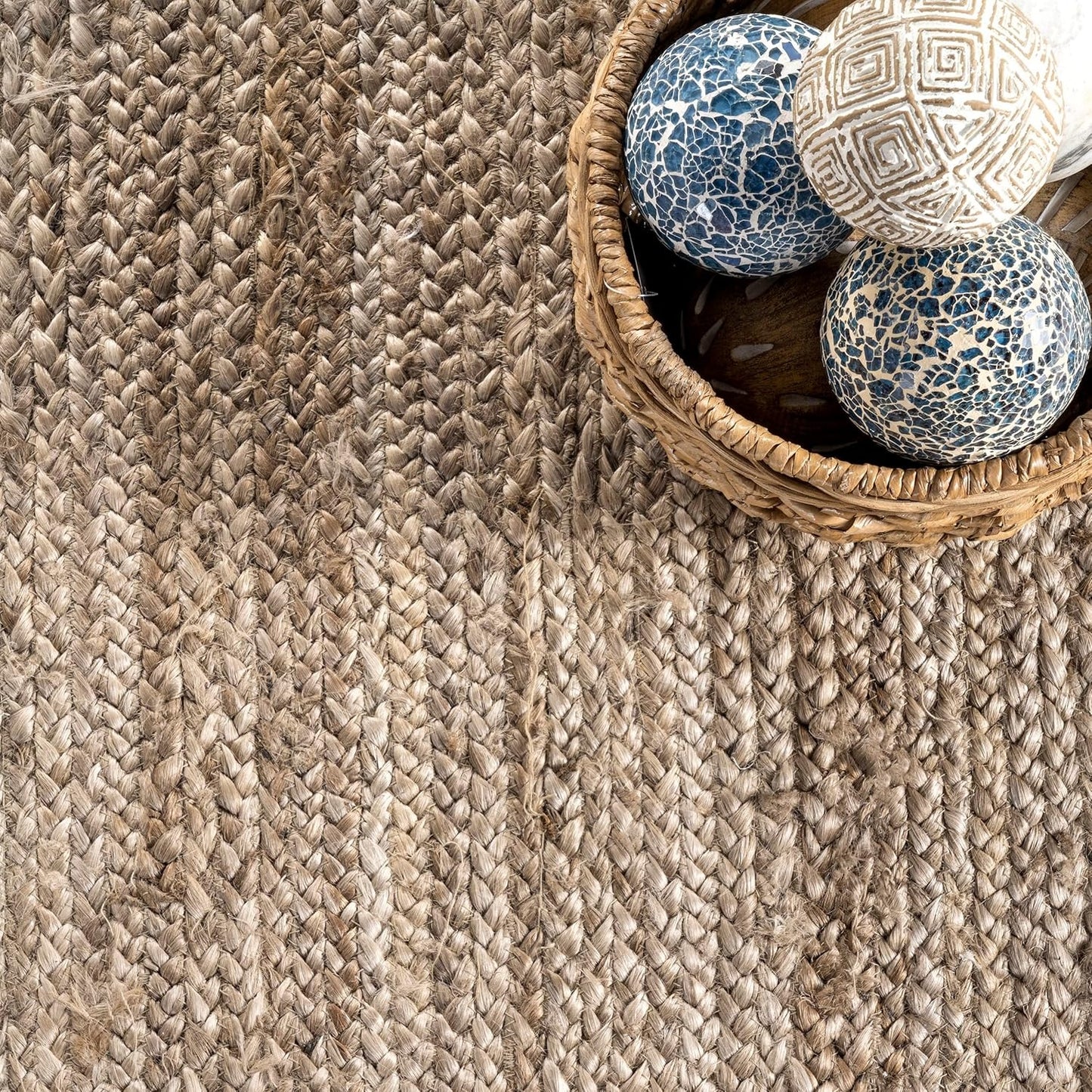 Textured woven rug with a basket containing decorative balls on a wooden floor.