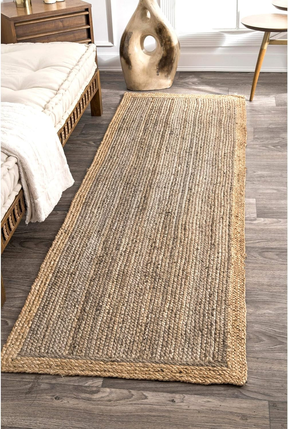 Woven jute rug on a wooden floor in a bedroom setting