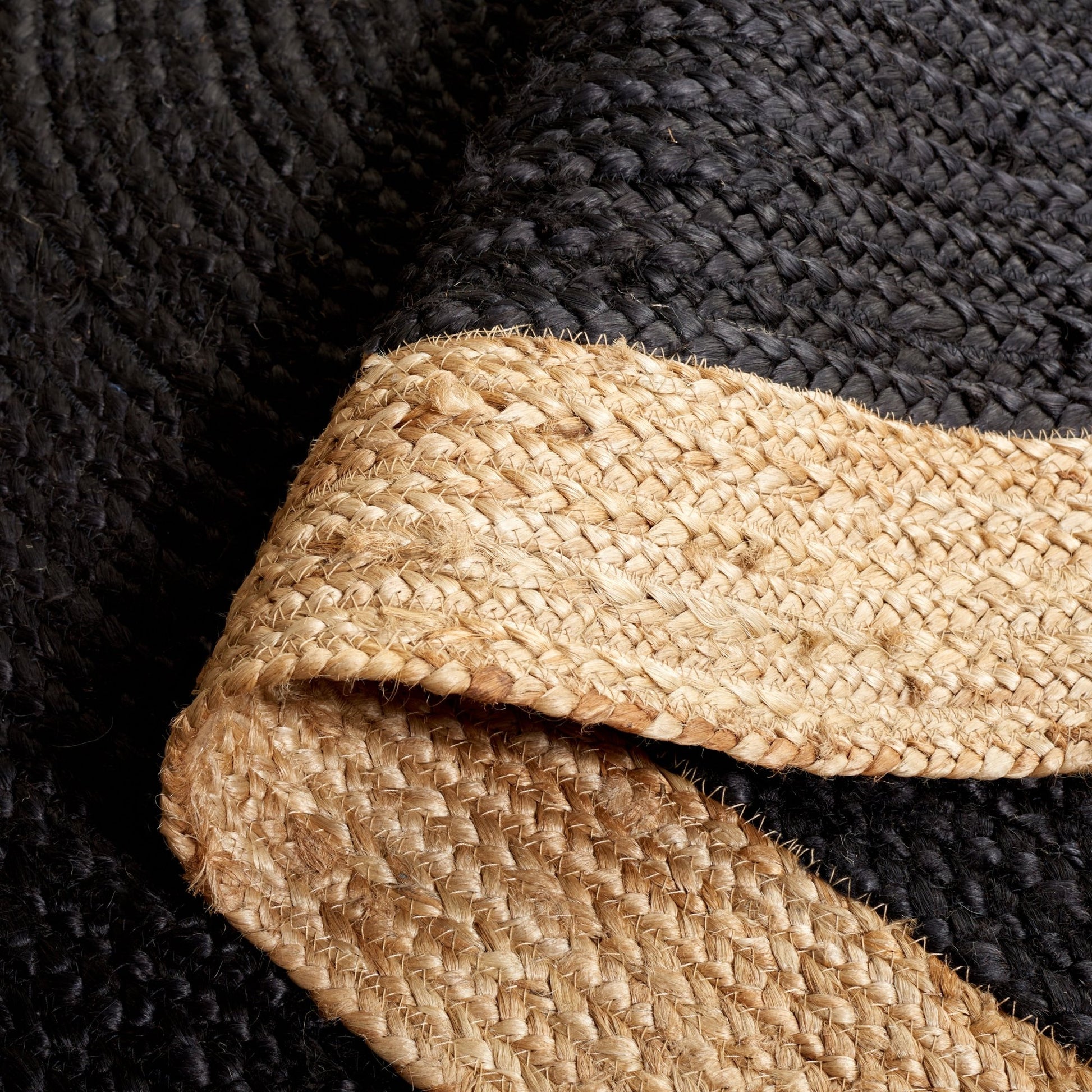 Close-up of a textured black fabric with a beige woven strip.