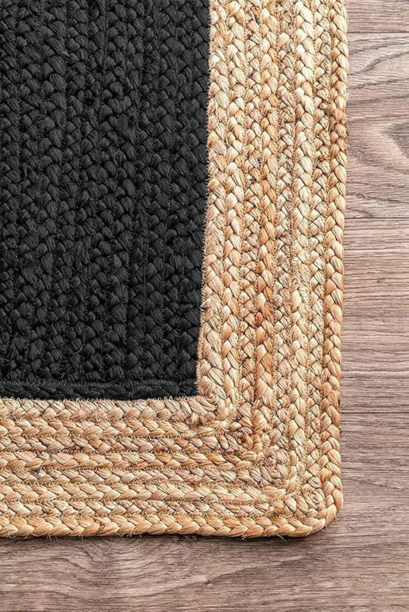 Black and beige woven rug corner on a wooden floor