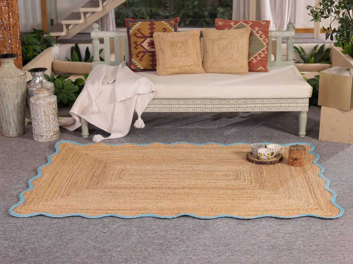 Woven mat on a gray floor with a couch and decorative pillows in the background