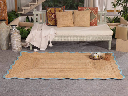 Woven mat on a gray floor with a couch and decorative pillows in the background