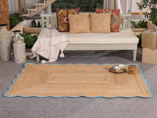 Woven mat on a gray floor with a couch and decorative pillows in the background