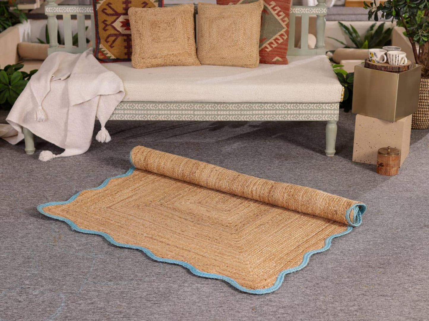 Rolled-out woven mat on a gray floor with a couch and decorative pillows in the background.