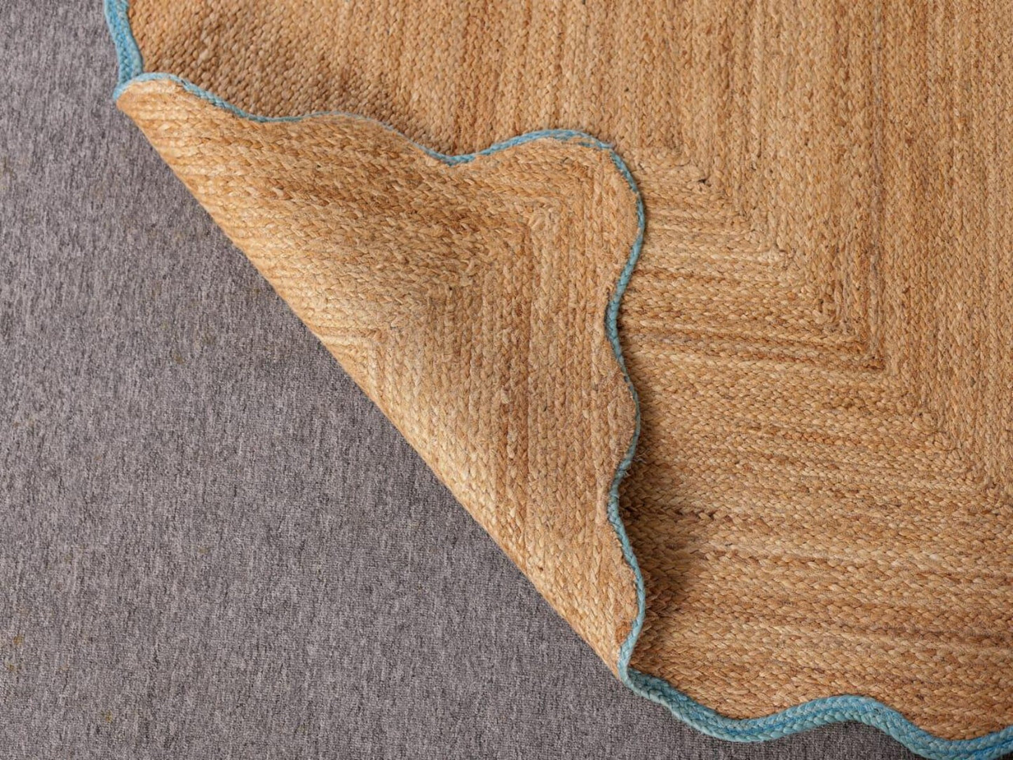 Close-up of a brown textured rug corner on a gray surface