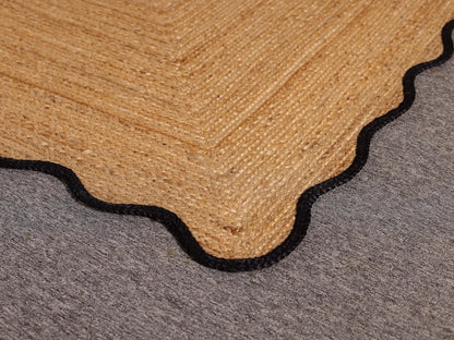 Close-up of a transition strip between a brown carpet and gray floor.