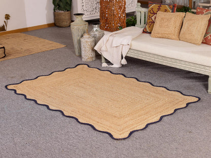 Beige woven rug with scalloped edge on a gray carpeted floor.