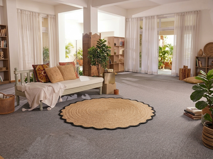 Living room with a round woven rug, sofa, and bookshelves.