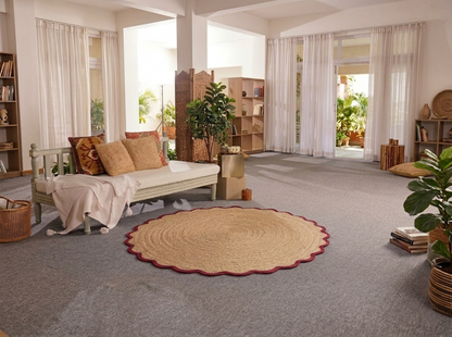 Living room with a round woven rug, sofa, and bookshelves.