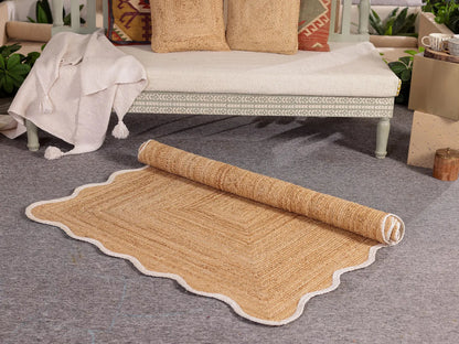 Rolled-out jute rug on a gray floor with a bench and decorative pillows in the background.